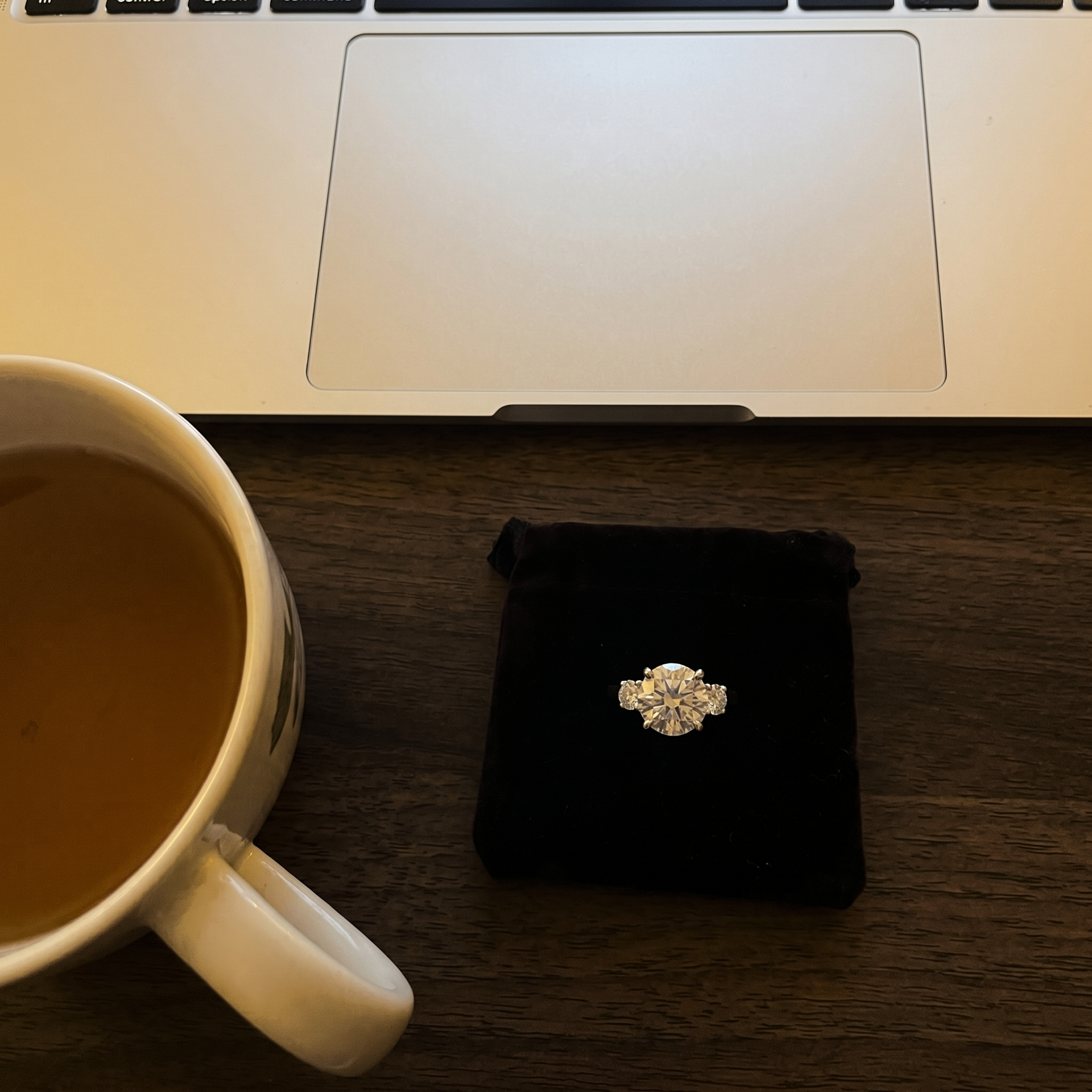 Late-night research with laptop and ring on the table