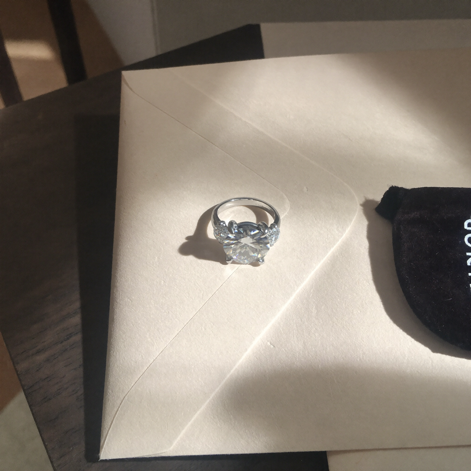 Close-up of the engagement ring on an envelope